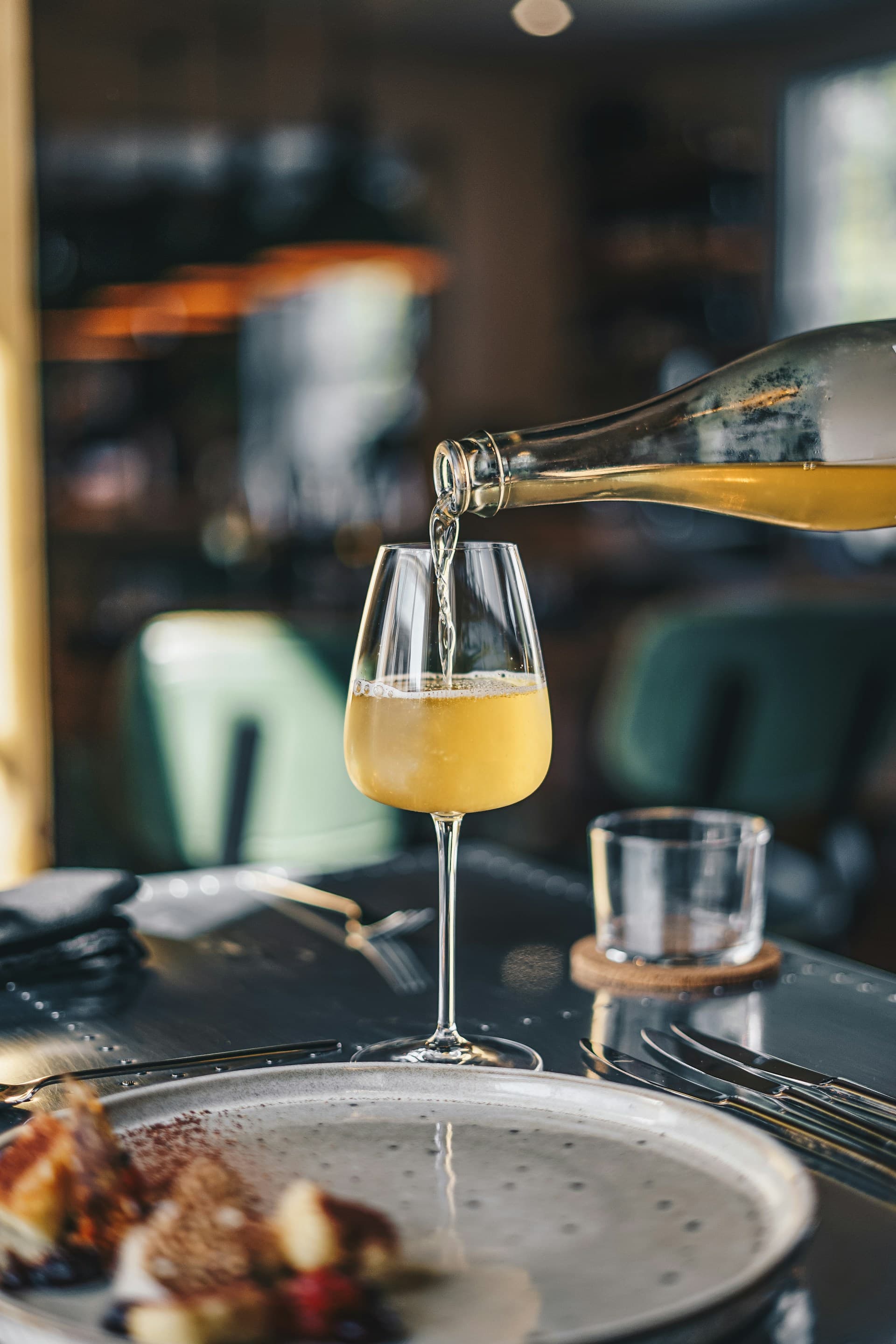Red wine being poured into a glass under warm light