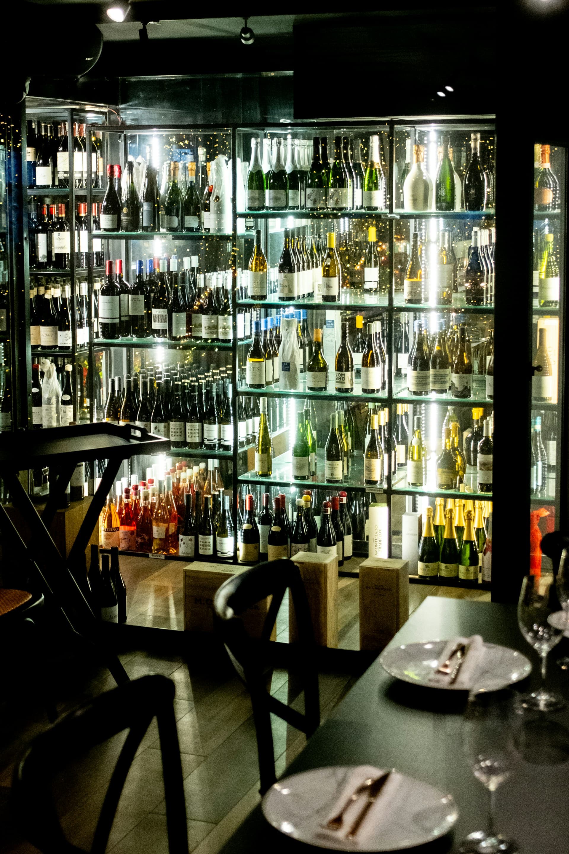 A wall of wine bottles in a dimly lit restaurant