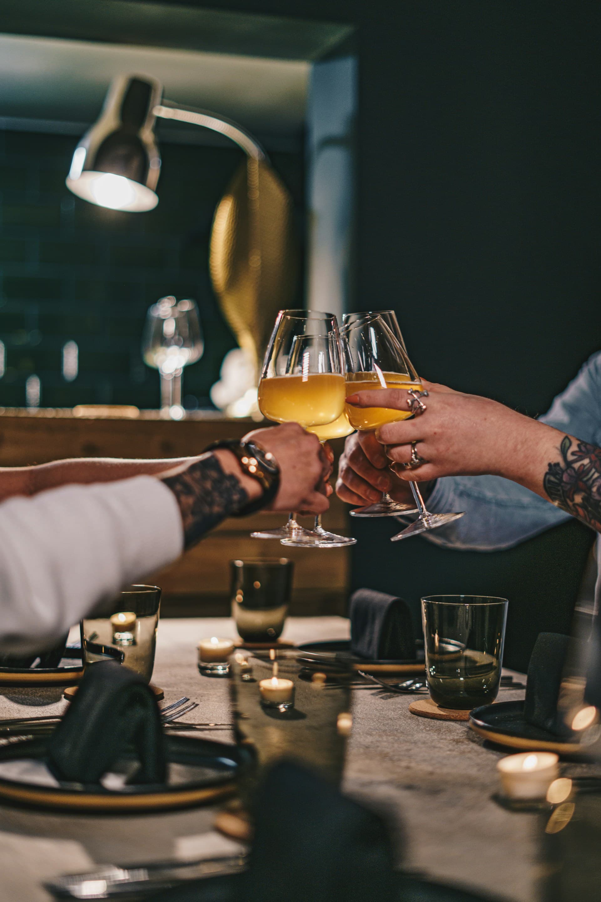Friends raising wine glasses together at a candlelit table during a tasting